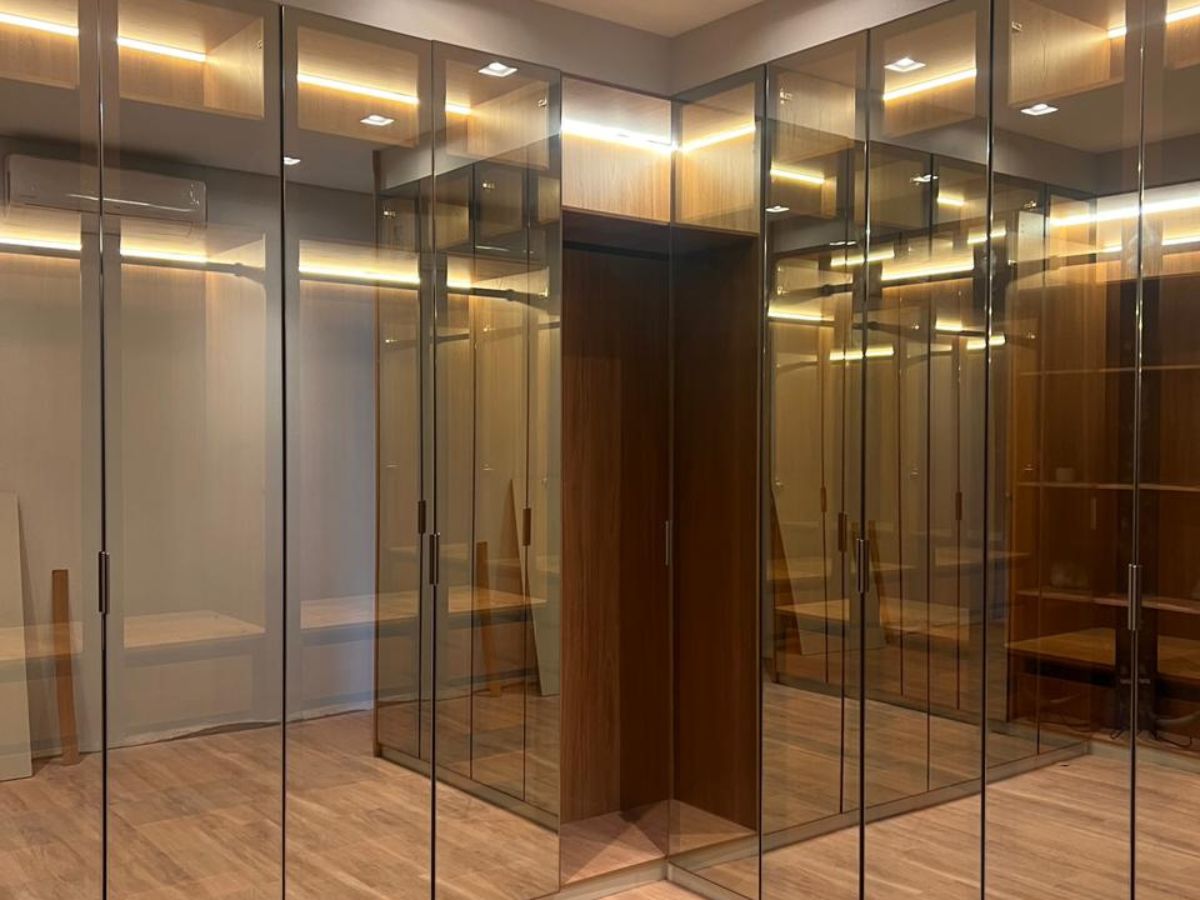 Detalhe de armário planejado XMad com portas espelhadas e iluminação embutida