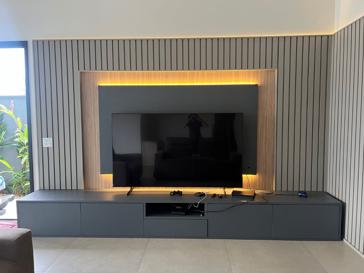 Sala planejada XMad com rack de TV, home theater e acabamento sob medida